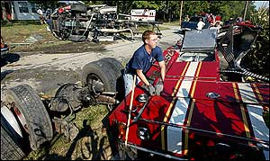 Volunteer firefighters and paramedics pull a firefighter from a fire truck involved in an accident in eastern Howard County, Ind., enroute to a call on Tuesday, Sept. 6, 2005. The truck flipped and hit a tree tearing the truck into three large pieces and scattering debris. The cellular 911 that prompted the fire truck to respond was actually made in another county.