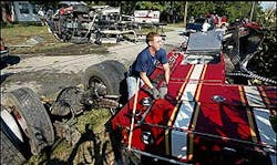 Volunteer firefighters and paramedics pull a firefighter from a fire truck involved in an accident in eastern Howard County, Ind., enroute to a call on Tuesday, Sept. 6, 2005. The truck flipped and hit a tree tearing the truck into three large pieces and scattering debris. The cellular 911 that prompted the fire truck to respond was actually made in another county. Volunteer firefighters and paramedics pull a firefighter from a fire truck involved in an accident in eastern Howard County, Ind., enroute to a call on Tuesday, Sept. 6, 2005. The truck flipped and hit a tree tearing the truck into three large pieces and scattering debris. The cellular 911 that prompted the fire truck to respond was actually made in another county.