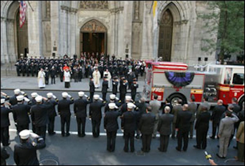 The flag-draped casket holding the remains of Firefighter Gerard Baptiste is saluted as it lies on top of a fire truck after funeral services at St. Patrick&apos;s Cathedral in New York, Wednesday Sept. 7, 2005.