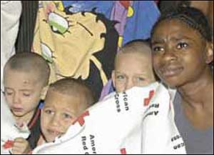 ESCAPE AT 4 A.M.: Three kids and a woman huddle in a Red Cross blanket yesterday after they were burned out of their home on Eagle Avenue in The Bronx.