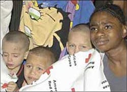 ESCAPE AT 4 A.M.: Three kids and a woman huddle in a Red Cross blanket yesterday after they were burned out of their home on Eagle Avenue in The Bronx. ESCAPE AT 4 A.M.: Three kids and a woman huddle in a Red Cross blanket yesterday after they were burned out of their home on Eagle Avenue in The Bronx.