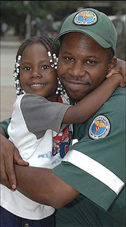 MY HERO: Emani McCovery, 4, yesterday embraces Damon Allen, who, with his partner, caught her when she was lowered from a fire escape. MY HERO: Emani McCovery, 4, yesterday embraces Damon Allen, who, with his partner, caught her when she was lowered from a fire escape.