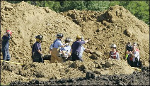 The second of two workers is removed from a hole they were trapped in after a trench caved-in on Tuesday, Sept. 27, 2005, in Overland Park, Kan. Rescue workers from Overland Park, Olathe and Consolidated No. 2 fire departments in Kansas, worked to free the men who were buried waist and chest-high.