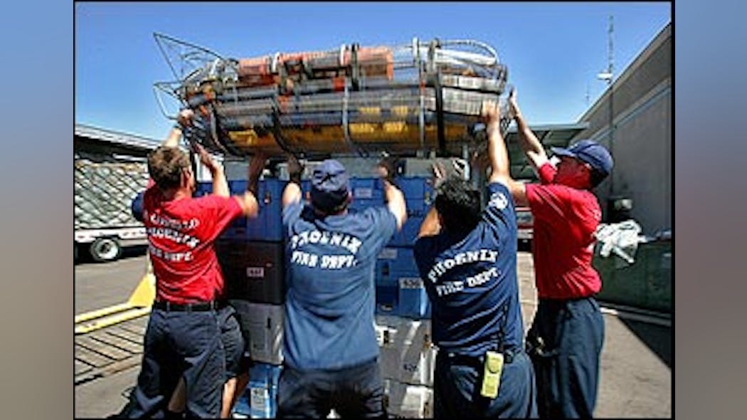 From left; Phoenix firefighter recruit Rory Costello, Capt. Tom Henry, Capt. Gilbert Cardenas and recruit Todd Yonker hoist rescue baskets atop a pallet of rescue supplies in this Tuesday, Aug. 30, 2005, file photo at the Phoenix Firefighter Training Academy in Phoenix, prior to leaving for New Orleans. Phoenix Fire department, which sent their search and rescue team to assist in the aftermath of Hurricanes Katrina and Rita, has had it&apos;s search and rescue teams suspended from operations by FEMA becasue it sent armed police officers to protect the firefighters during their deployement to the Gulf Coast. At issue is a rule in FEMA&apos;s Code of Conduct that prohibits Urban Search and Rescue teams from having firearms.