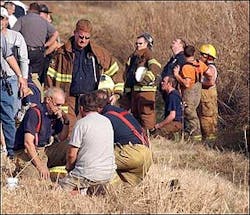 Greg Hickman, Neosho fire chief, and Andy Nimmo (standing), Redings Mills fire chief, huddle around each other hours after losing a fireman to death while fighting a fire at Ragland Mills, located just outside the Neosho city limits on 14079 Hammer Road. As of 5 p.m., the name of the fireman has not been released.