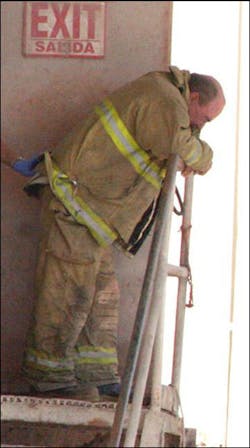 A Neosho firefighter gets some air after learning a fellow firefighter, Timmy Hardy, was trapped inside of a bin at Ragland Mills. Hardy died as a result.