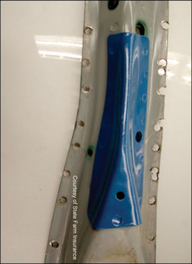 The opposite side of the Subaru Forester B-pillar clearly shows the additional high-strength, high-tension steel added at the mid point of the pillar. Blue paint has been added to enhance its visibility for training purposes. Note the location of the top door hinge mounting holes to better understand where this reinforcement is located in relation to the vehicle itself.