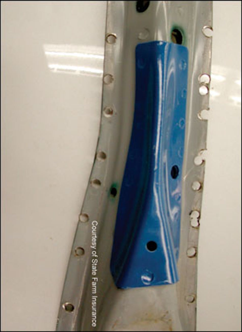 The opposite side of the Subaru Forester B-pillar clearly shows the additional high-strength, high-tension steel added at the mid point of the pillar. Blue paint has been added to enhance its visibility for training purposes. Note the location of the top door hinge mounting holes to better understand where this reinforcement is located in relation to the vehicle itself.