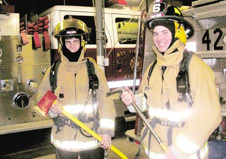 Bryan and Lee J. Shattret try on firefighting gear. The two are members of the Rye Fire Department&rsquo;s new Explorer program.