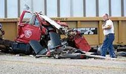 A New Summerfield firefighter looks at the twisted wreckage of his department's water tanker after the vehicle struck a Union Pacific train Saturday afternoon. A New Summerfield firefighter looks at the twisted wreckage of his department's water tanker after the vehicle struck a Union Pacific train Saturday afternoon.
