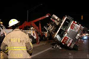 A Prince George's firefighter observes a tower ladder that rolled on its side while responding to a structure fire.