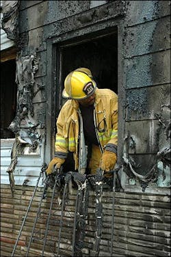 Lt. Terrance Andrews with Engine 15 leans out the window he used to pull Virginia Humphrey to safety. Part of the security bars he pulled away can be seen below the window. Lt. Terrance Andrews with Engine 15 leans out the window he used to pull Virginia Humphrey to safety. Part of the security bars he pulled away can be seen below the window.