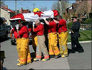 Wolfe Island firefighters carry the casket of volunteer firefighter Gary Bryant from the funeral hom