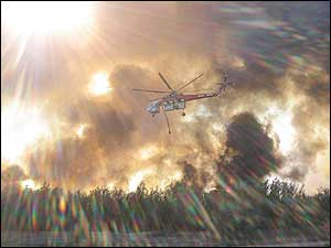 A helicopter releases water on a fire in San Marcial, N.M.