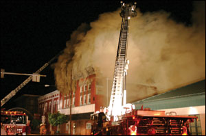 Osceola Mills Engine 22-2 supplies Madera Tower 25 on Presqueisle Street (side D) as its crew advances attack lines to the second floor. At left is Alpha Tower 5-16, which operates its ladder pipe, supplied by Houtzdale Engine 23-1.