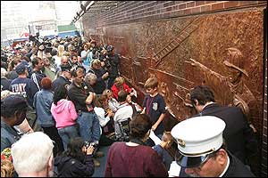 Family members and friends of firefighters who died in the Sept. 11 attacks gather in front of the memorial dedicated to the New York City Fire Department after the unveiling ceremony outside Engine 10/Ladder 10, June 10.