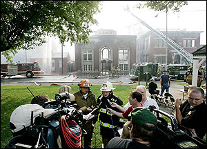 MADISON IN USA -- City of Madison Fire Chief Steve Horton, left, and Indiana State Fire Marshal Roger Johnson hold a briefing in front of the smoldering remains of the Elks Lodge after fire consumed it and damaged several other buildings in Madison, Ind., Friday, Aug. 25, 2006.