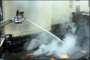 Firefighters pour water into the scene of a third alarm fire at 1575 Walton Avenue in the Concourse section of the Bronx borough of New York, the scene of a third alarm fire, Sunday, Aug. 27, 2006. Five firefighters were trapped and later rescued from inside the building after a partial collapse of the structure. One of them later passed away.