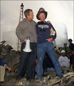 As rescue efforts continue in the rubble of the World Trade Center, President Bush puts his arms around firefighter Bob Beckwith while standing in front of the World Trade Center debris during a tour of the devastation, in this Sept. 14, 2001, file photo.