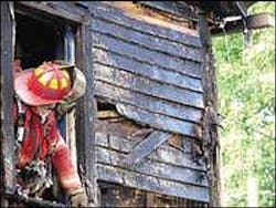 A Kreamer firefighter peers out of a second-floor window of the home of firefighter James Mitch Sept. 25. A Kreamer firefighter peers out of a second-floor window of the home of firefighter James Mitch Sept. 25.