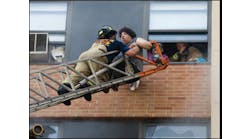 Firefighters rescue occupants by aerial ladder.