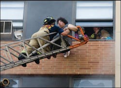 Firefighters rescue occupants by aerial ladder. Firefighters rescue occupants by aerial ladder.