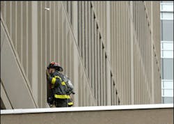 A firefighter looks into the window of a 17-story office building owned by the Massachusetts Institute of Technology, that was evacuated after smoke filled stairways and set off alarms Friday, Dec. 8, 2006, in Cambridge, Mass. A firefighter looks into the window of a 17-story office building owned by the Massachusetts Institute of Technology, that was evacuated after smoke filled stairways and set off alarms Friday, Dec. 8, 2006, in Cambridge, Mass.