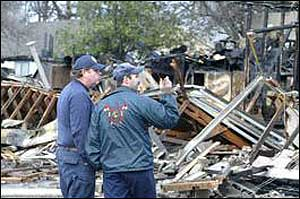The Denison fire marshal, left, talks with the state fire marshal about a fire on Crockett Avenue in Denison.