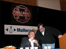 NFFF Executive Director Ron Siarnicki judges chili with emcee Billy Goldfeder looking on. NFFF Executive Director Ron Siarnicki judges chili with emcee Billy Goldfeder looking on.
