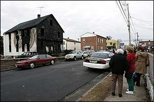 Neighbors look at the remains of a house in Manville, N.J.