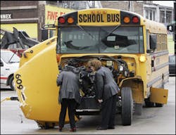 nvestigators check the damage to the front of a school bus that collided with a fire truck responding to a call Friday morning, March 23, 2007, on Chicago&apos;s South Side.
