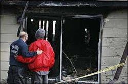 Cahokia Fire Department training officer Cris Burch comforts the boyfriend of the mother who perished in the house fire. Cahokia Fire Department training officer Cris Burch comforts the boyfriend of the mother who perished in the house fire.