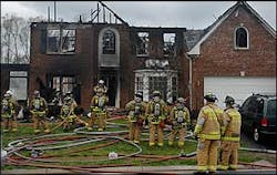 Firefighters gather in front of the house in which Firefighter was killed while searching for residents. Firefighters gather in front of the house in which Firefighter was killed while searching for residents.