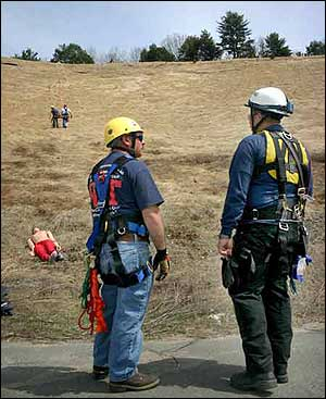 Brad Reed, right, a firefighter with the St. Johnsbury Fire Department, and Marc Brown, with Lyndonville, wait for assistance Thursday afternoon during a training exercise along Route 5 in St. Johnsbury.