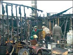 Dick Phillips, owner of of Vermont Field Sports, center, examines the remains of his Middlebury sporting goods store. Dick Phillips, owner of of Vermont Field Sports, center, examines the remains of his Middlebury sporting goods store.