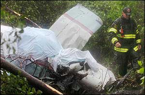 A Canton, Mass. firefighter walks past the wreckage of a single-engine aircraft in a wooded area in Canton, June 4.