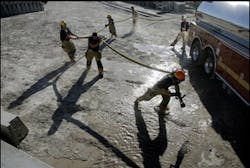 Firefighters carry a water hose near a tire fire in Las Vegas, Wednesday, June 20, 2007. Nearly 100 firefighters were dispatched to tackle the blaze that consumed a pile of tires stored in a lot west of the downtown casino corridor. Firefighters carry a water hose near a tire fire in Las Vegas, Wednesday, June 20, 2007. Nearly 100 firefighters were dispatched to tackle the blaze that consumed a pile of tires stored in a lot west of the downtown casino corridor.
