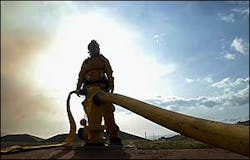 A Maui fire fighter fills up a temporary water tank used by helicopters while helping battle a wildfire in Olowalu, June 27. A Maui fire fighter fills up a temporary water tank used by helicopters while helping battle a wildfire in Olowalu, June 27.