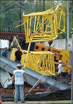 Crews remove a fallen crane from the site after it collapsed Monday. Crews remove a fallen crane from the site after it collapsed Monday.