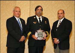 Chris Neal, Director Fire Protection Publications (left); Chief Billy Goldfeder; and Jeff Morrissette, IFSTA Board President.