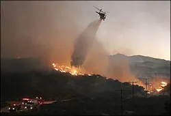A helicopter drops water on a brush fire in Acton, Calif., Sept. 3. A helicopter drops water on a brush fire in Acton, Calif., Sept. 3.