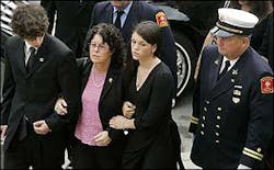 Adam Cahill, left, his mother Anne and her daughter Shawna, right, enter Holy Name Catholic Church in Boston, Sept. 6.