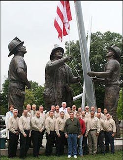 Members of the executive fire officer class pose with the scupltor, Stan Watts (in green shirt). Members of the executive fire officer class pose with the scupltor, Stan Watts (in green shirt).