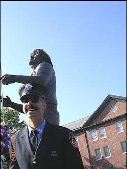 Billy Eisengrein stands in front of his statue, &apos;To Lift a Nation.&apos;