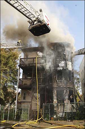 A charred triple-decker house smolders after a three-alarm fire, Nov. 12.