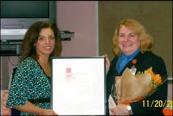 A Dunkin Brands representative presents Diana Pfersick (right) with her awards.
