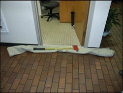 This tarp has been folded in half and rolled to make a dike to prevent water from entering the bathroom. The pick head axe provides some weight to help the dike keep water out. This tarp has been folded in half and rolled to make a dike to prevent water from entering the bathroom. The pick head axe provides some weight to help the dike keep water out.