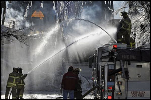 Firefighters hose down a synagogue, Saturday, Dec. 15, 2007 following an eight-alarm fire in Gloucester, Mass. One person was killed in the fire, and the synagogue and an apartment building were destroyed.
