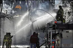 Firefighters hose down a synagogue, Saturday, Dec. 15, 2007 following an eight-alarm fire in Gloucester, Mass. One person was killed in the fire, and the synagogue and an apartment building were destroyed.