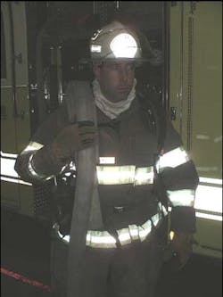 Photo No.6: Here the Backup firefighter has his shoulder load properly draped on his shoulder, leaving his opposite hand free to help move up a stairway, past occupants, or pull a chock from his helmet band or pocket.